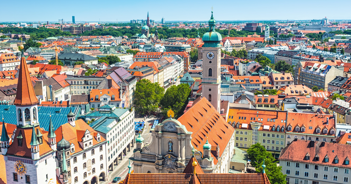 A breathtaking aerial view of Munich, showcasing its historic architecture, red-tiled roofs, and vibrant cityscape.