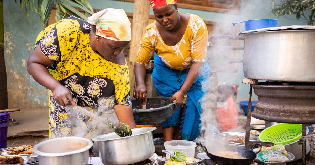 African woman cooking traditional food at street