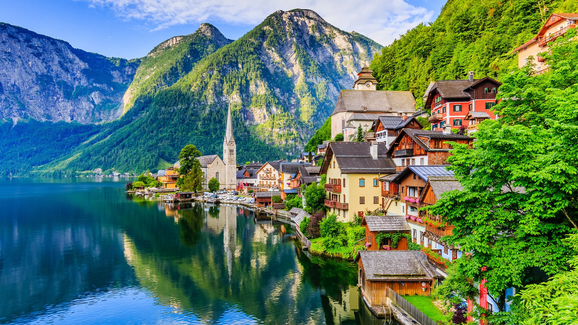 Hallstatt, a picturesque Austrian village nestled amidst mountains and reflected in the calm waters of Lake Hallstatt.