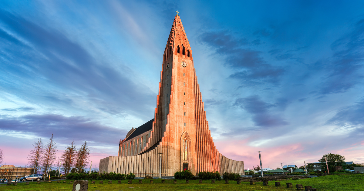 The majestic Hallgrimskirkja church in Reykjavik, with its towering spire and stunning architecture, illuminated by a beautiful sunset sky.