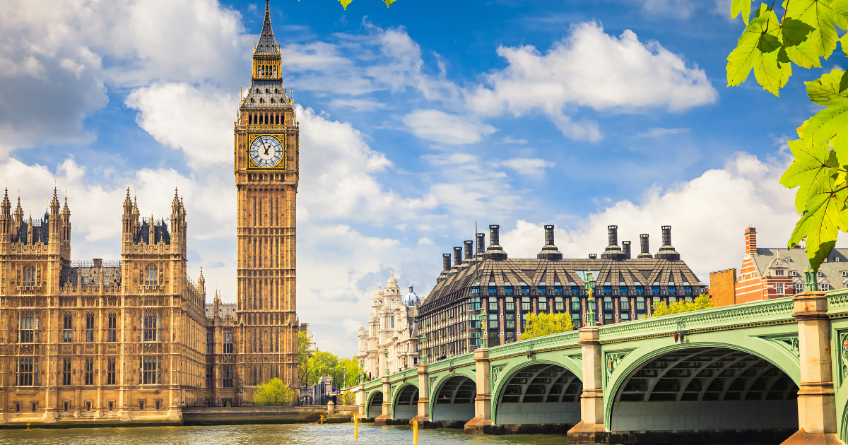 A view of the iconic Big Ben clock tower and the Houses of Parliament, with the River Thames flowing in the foreground.