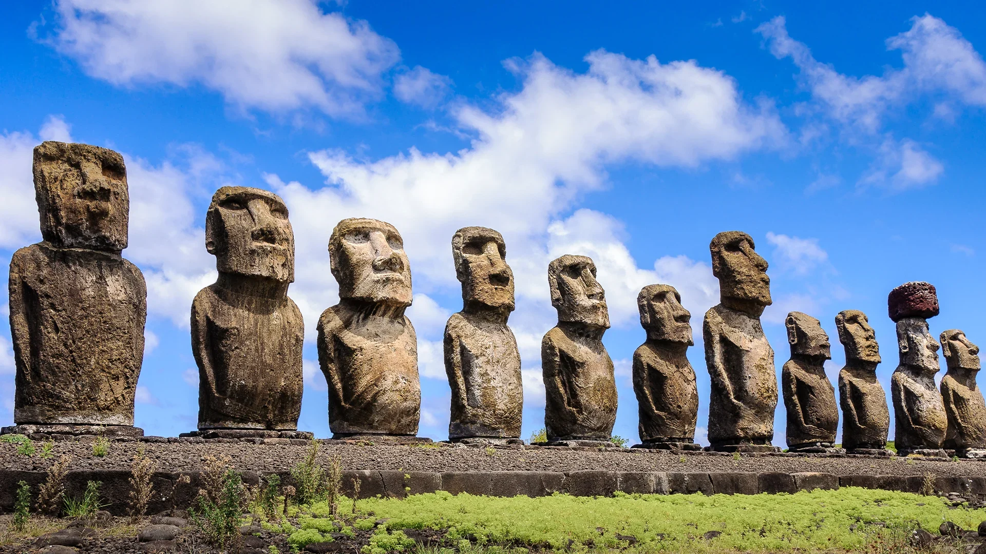 A row of the iconic Moai statues, large stone figures with distinctive faces, on Easter Island.