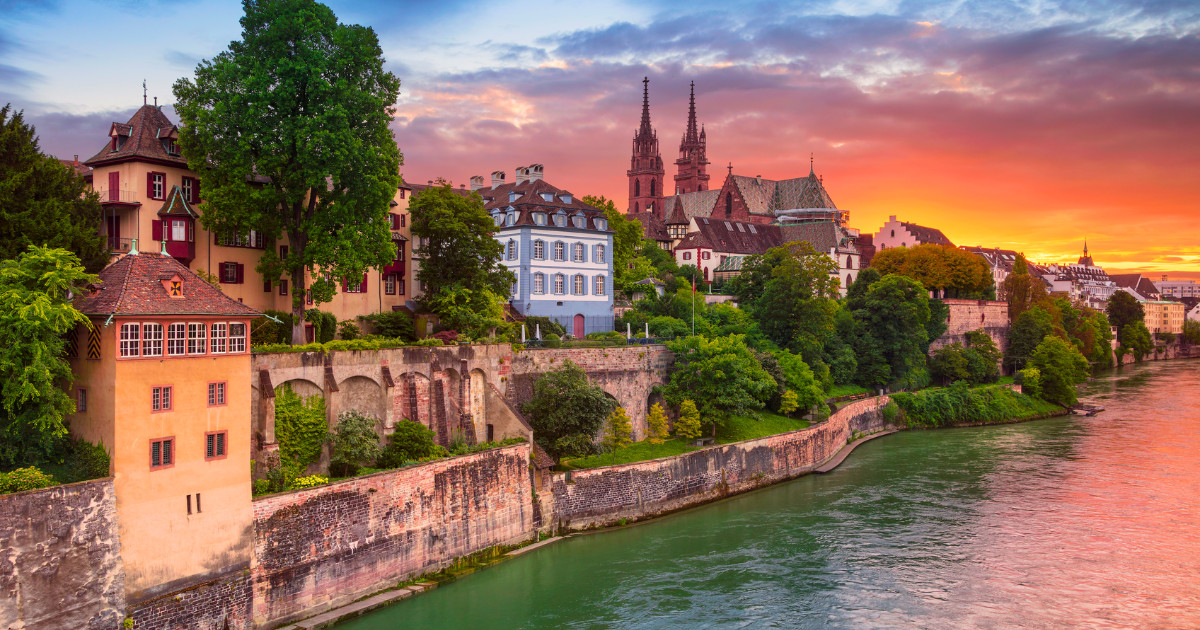 Cityscape image of Basel, Switzerland during dramatic sunset.