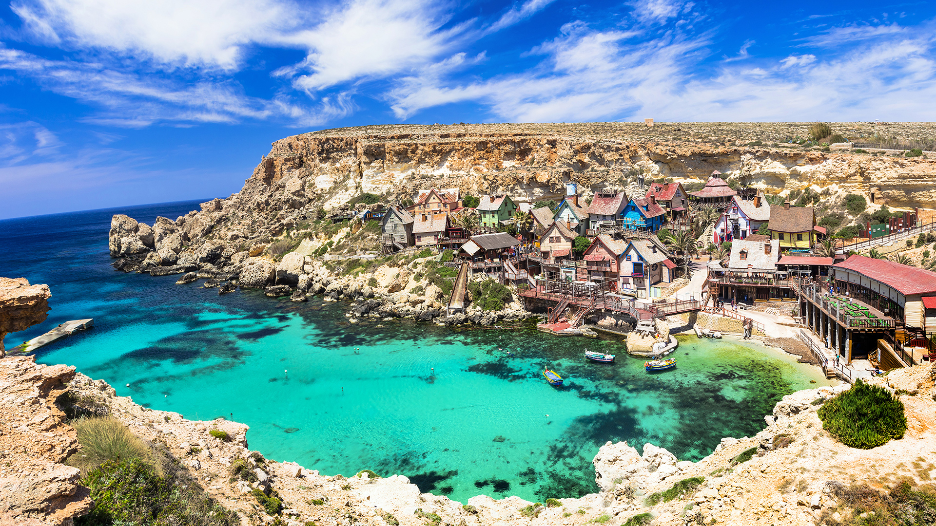 A stunning view of Popeye Village in Malta, a colorful seaside village built for the 1980 musical film Popeye.