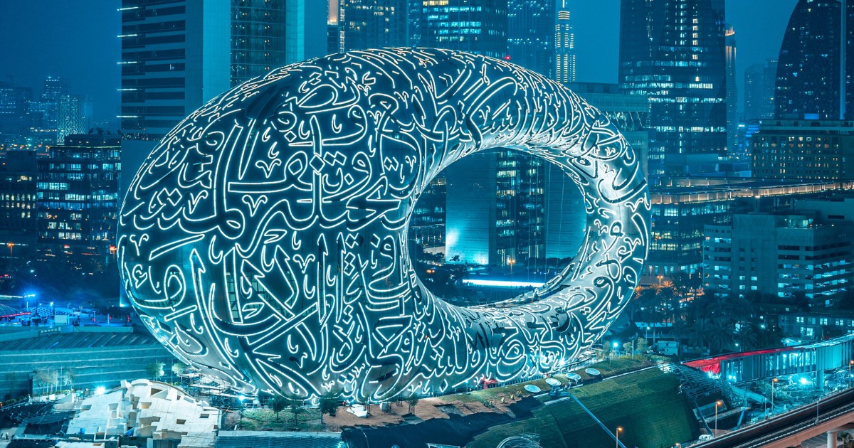 The futuristic Museum of the Future in Dubai, with its distinctive Arabic calligraphy-inspired facade, lit up against the backdrop of the city skyline.