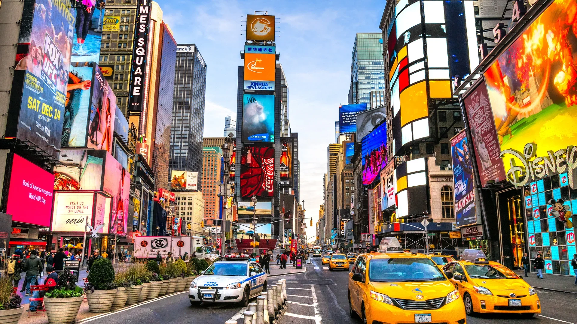 The iconic Times Square in New York City, with its brightly lit billboards, advertisements, and yellow taxis.