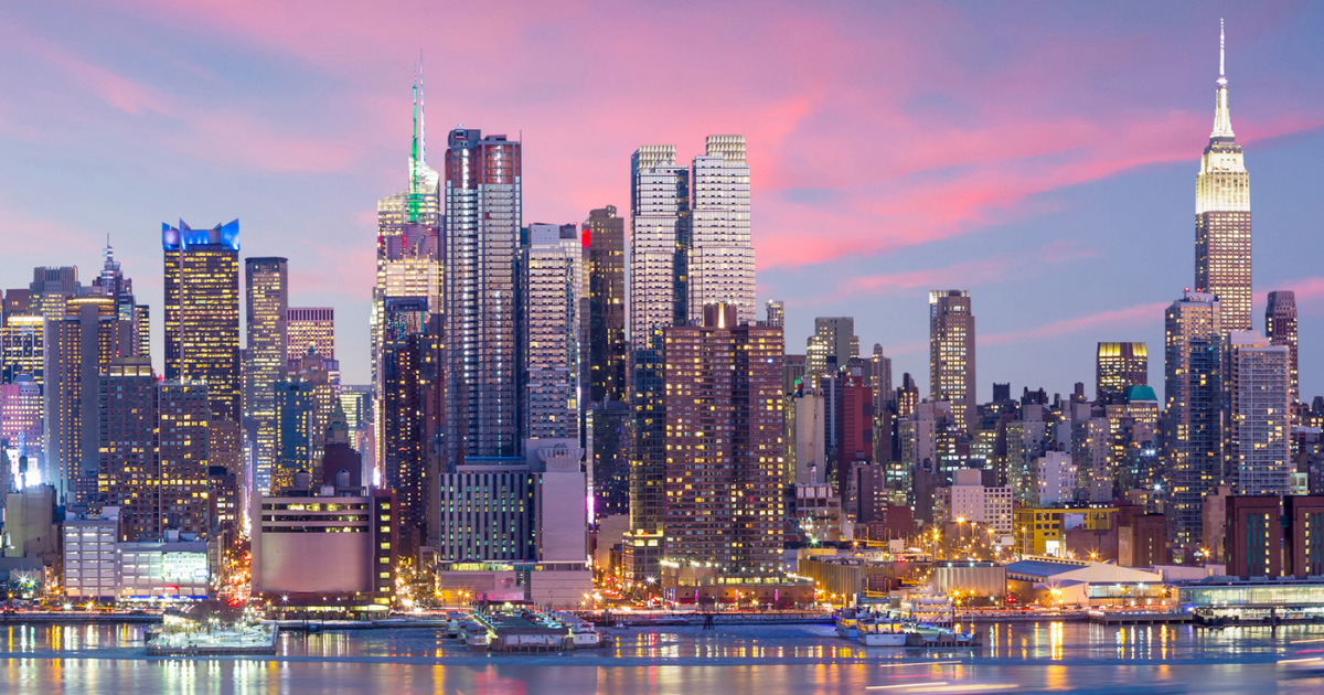 A stunning view of the New York City skyline at twilight, with iconic skyscrapers like the Empire State Building illuminated against a colorful sky.