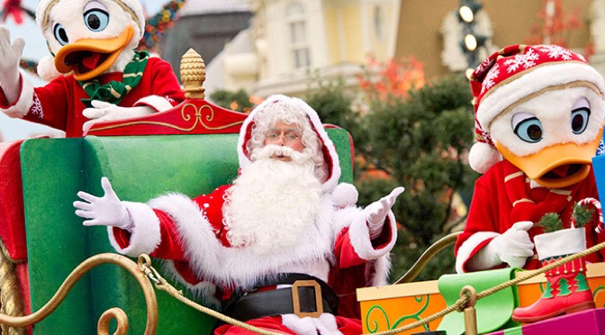 Santa Claus, Mickey Mouse, and Donald Duck in festive attire riding a sleigh in a Christmas parade at a Disney park.