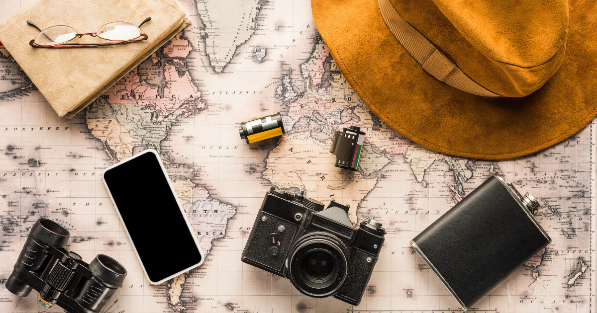 An array of Travel Essentials placed on a world map