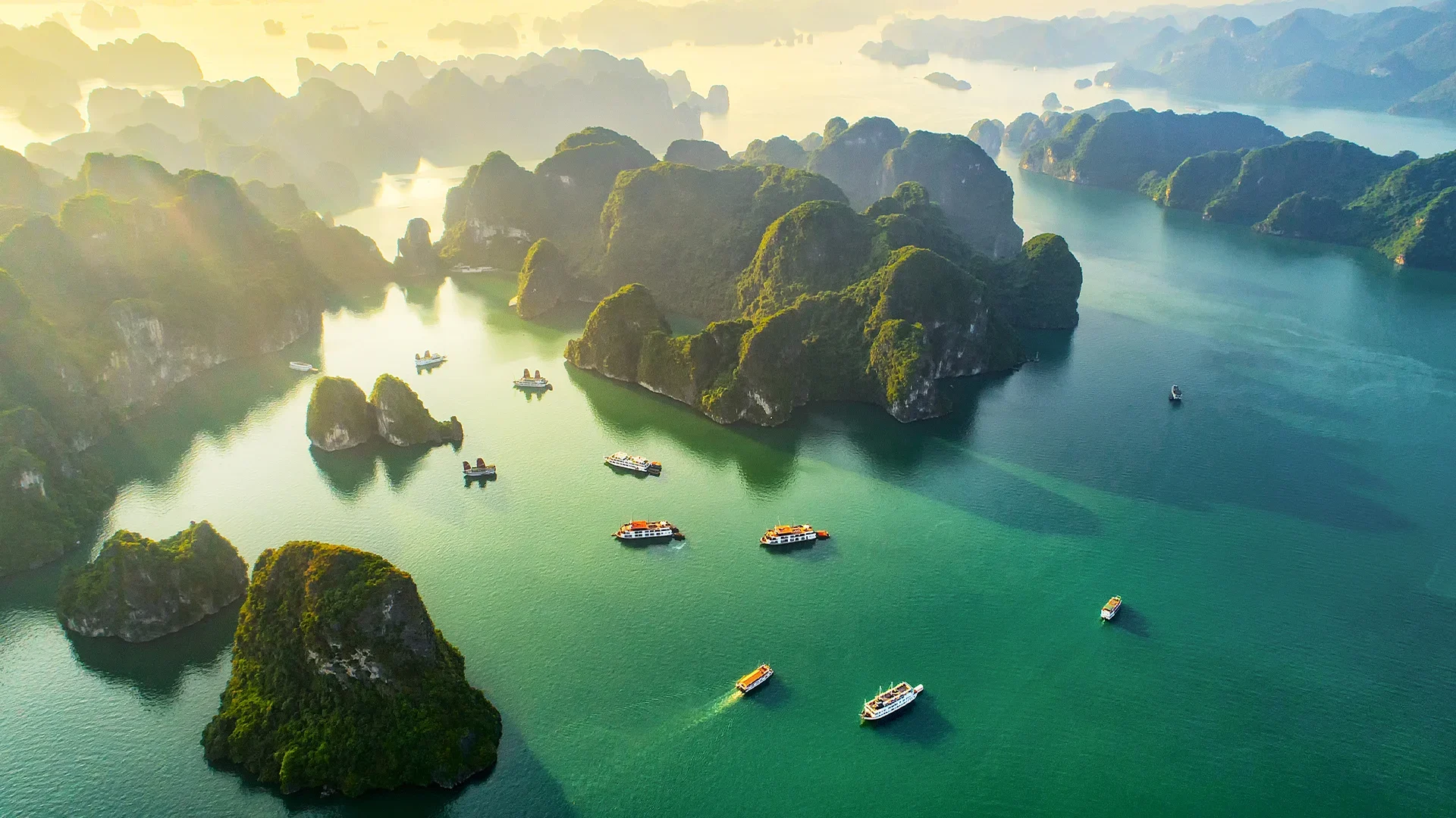 An aerial view of Ha Long Bay in Vietnam, with numerous limestone karsts and islands dotted across the turquoise water.